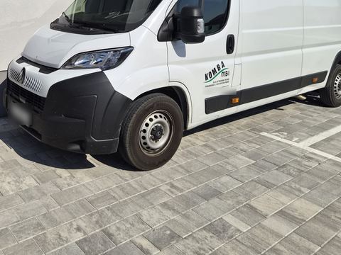 Bijelo kombi vozilo KOMBA MBI s logotipom tvrtke na vratima